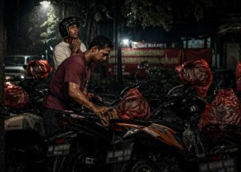 Bukan Cuma Tarik Uang: Saat Hujan, Tukang Parkir Ini Bekerja Lebih